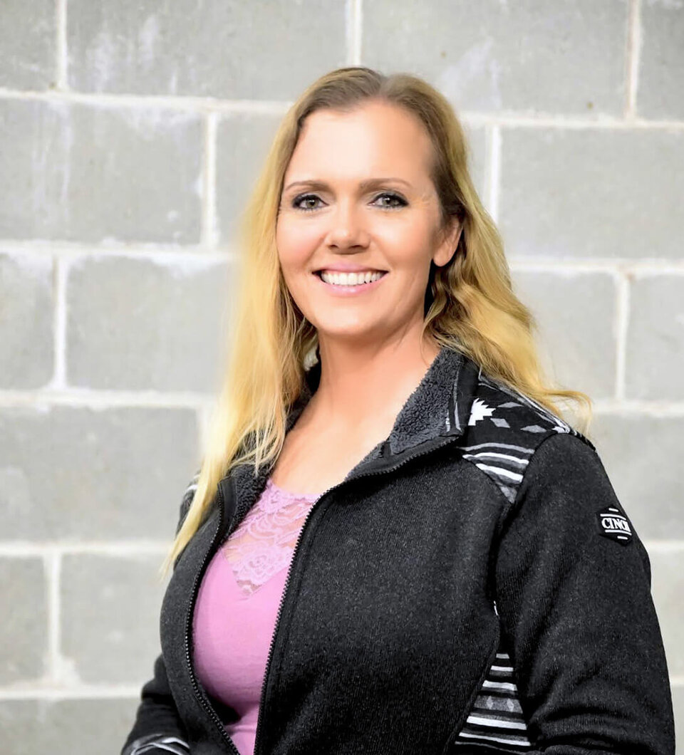A smiling woman standing in front of a wall