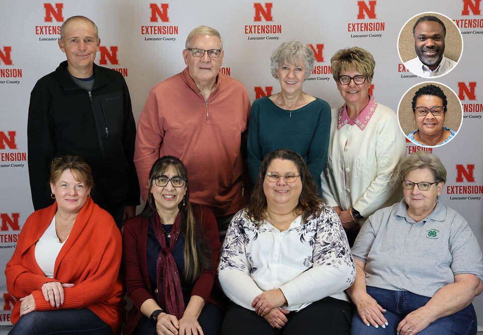 A group of two rows of smiling people, with two inset headshots