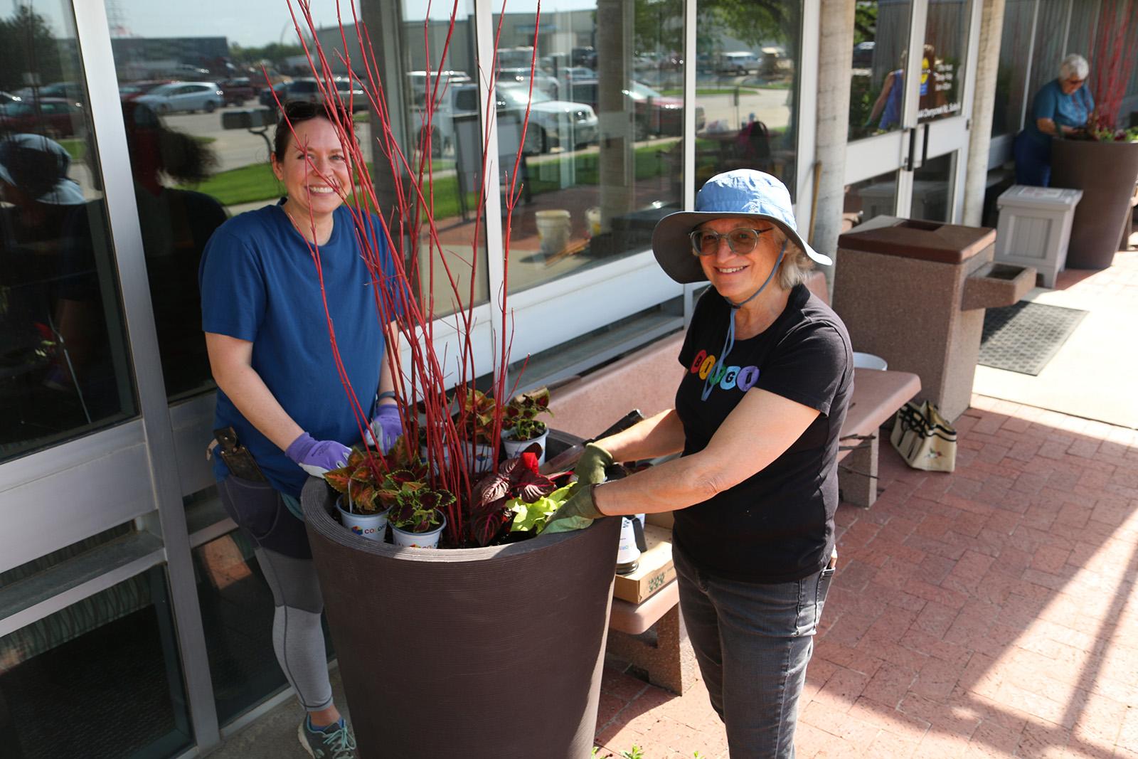 Two women working on potted planters